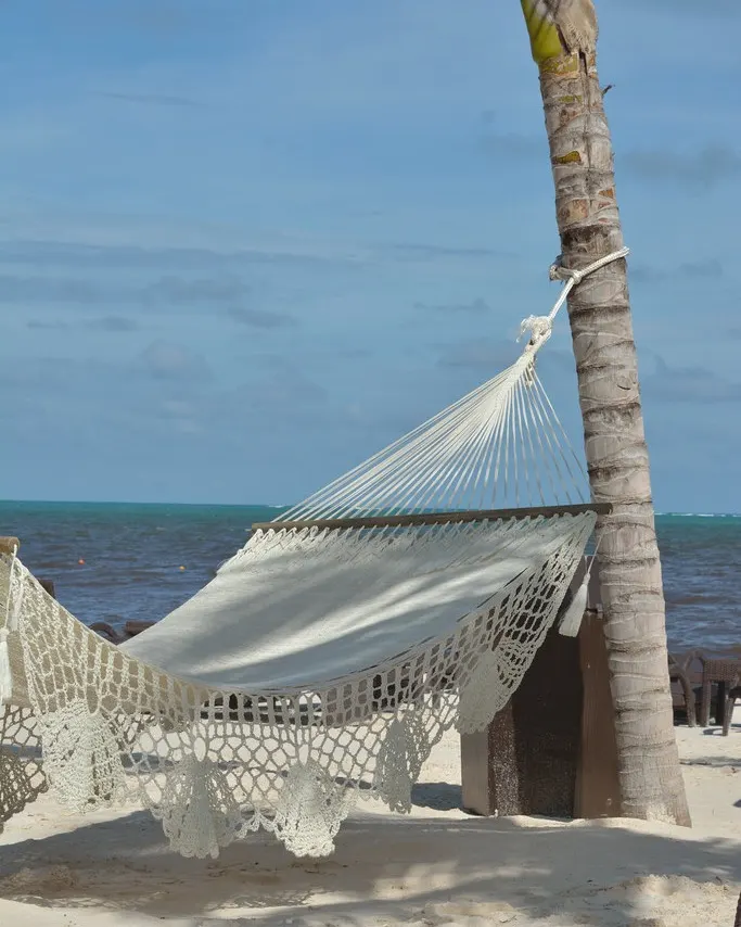 Hammock over turquoise water on the wide, calm beach near Royalton Riviera Cancún, in the Bahía Petempich area