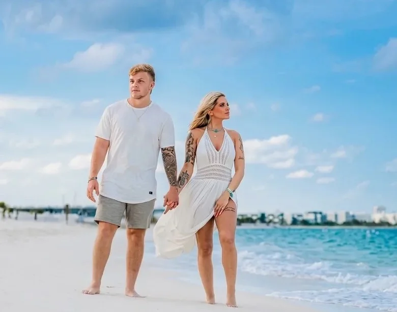 Couple walking hand in hand along the shoreline during a sunrise photo session in Playa del Carmen