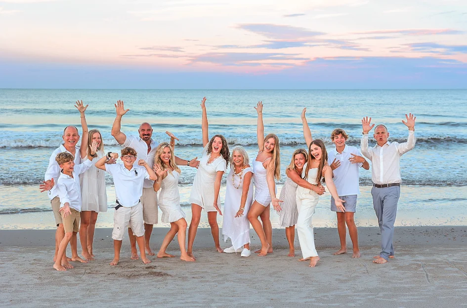 Three generations of one family posed together on the open sand during a group photo session in Playa del Carmen